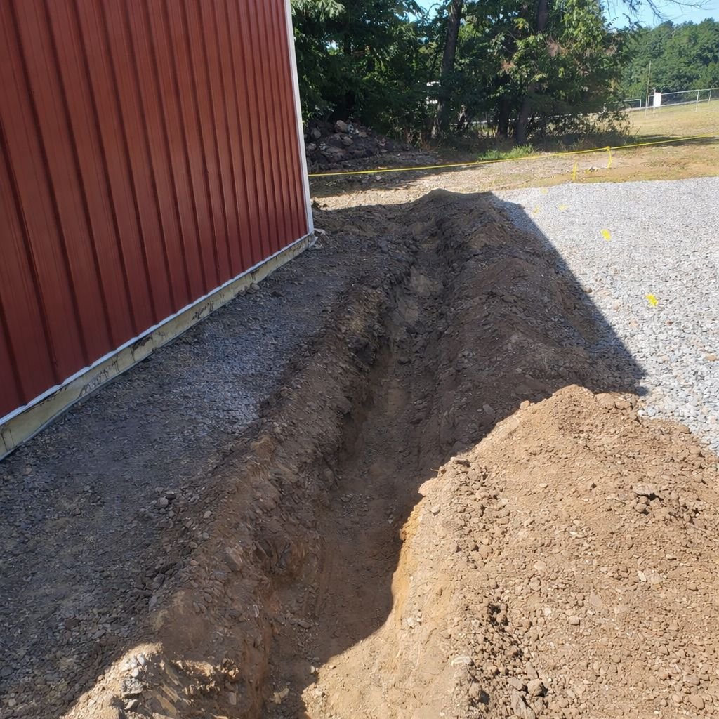 Precision trenching job on gravel lot with safety cones in Blairstown NJ
